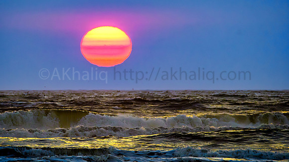 Fading sun and glowing waves