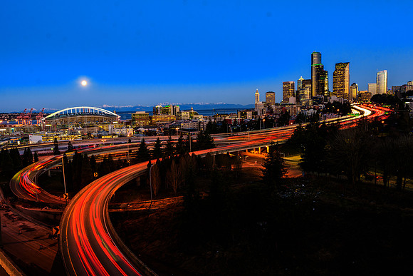City's first spring morning - folks heading to work and super moon heading to Olympics under clear blue skies.
